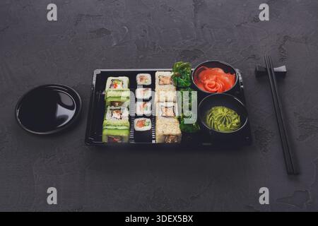 Set Sushi Maki und Brötchen in Großansicht im Lieferkarton Stockfoto