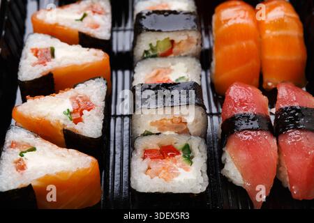 Set Sushi Maki und Brötchen in Großansicht im Lieferkarton Stockfoto