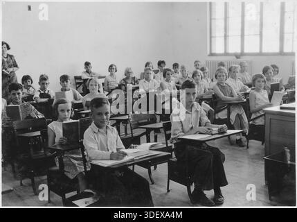 Dieses Foto zeigt eine vierte Klasse an einer öffentlichen Schule in Boulder City, Nevada, die wahrscheinlich in den 1930er Jahren aufgenommen wurde Boulder City war eine geplante Gemeinde, die für Arbeiter und Familien gebaut wurde, die am Bau des Hoover Dam beteiligt waren, eines der größten Infrastrukturprojekte des New Deal. Bilder wie diese, die von NARA (National Archives and Records Administration) aufbewahrt wurden, dokumentieren Alltag, Bildung und Kindheit in föderal geplanten Städten während der Großen Depression und heben die Rolle der Regierung bei der Gestaltung der sozialen und industriellen Entwicklung hervor. Stockfoto