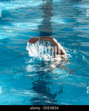 Eine Schwimmerin schwimmt im Morgenlicht in einem Pool. Stockfoto