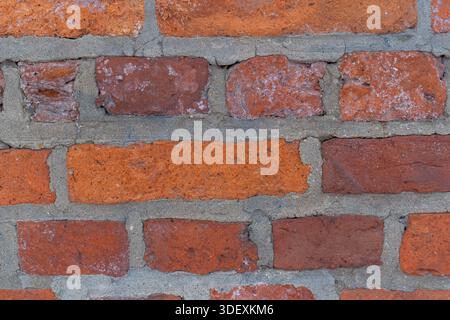 Hintergrund der alten roten Backsteinwand, architektonische Details aus nächster Nähe. Stockfoto