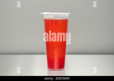 Ein Glas roter Beerenblütentee mit einer tiefen granatroten Farbe Stockfoto