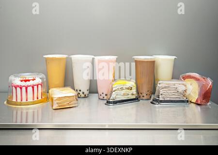 Ein Regenbogenblütentee mit Sirupe verschiedener Geschmacksrichtungen und Farben, sorgfältig in einem hohen Glas, ohne sich zu mischen, bildet lebendigen horizonta Stockfoto