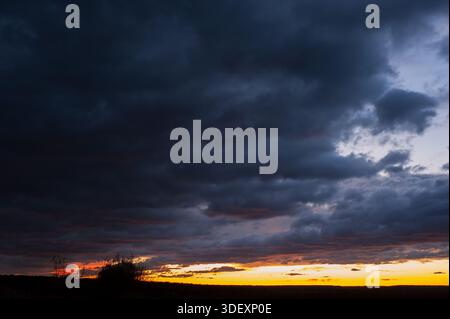 Sommersonnenuntergang über dem Weizenfeld. Wunderschöner Sonnenuntergangshimmel über der Landschaft Stockfoto