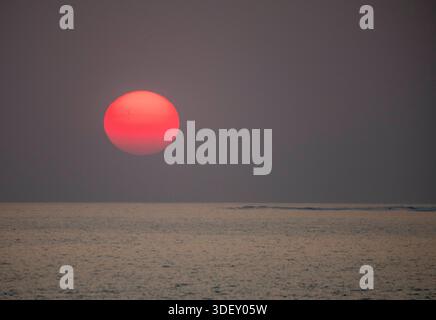 Die Sonne untergeht über dem Mosambik-Kanal, von der Salary Bay aus gesehen. Madagaskar. Die Salary Bay liegt perfekt an der Westküste Madagaskars und bietet einen ununterbrochenen Blick auf den Horizont des riesigen Mosambik-Kanals. Stockfoto