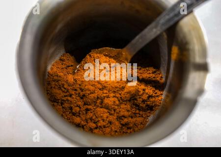 Fein gemahlener griechischer Kaffee in einem traditionellen Briki-Topf, bereit für die Zubereitung auf dem Herd. Eine Nahaufnahme, die mediterrane Kaffeerituale feiert. Stockfoto