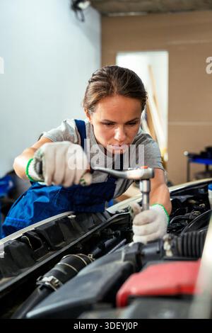 Weibliche Automechanikerin repariert das Auto in der Werkstatt Stockfoto