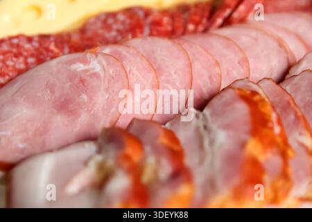 Nahaufnahme einer Auswahl an Fleischscheiben und Würstchen, einschließlich Schinken, Salami und geräuchertem Fleisch. Gourmet-Feinkost-Fleischplatte. Verschiedene Delikatessenartikel Stockfoto