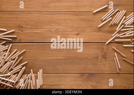 Farbige Holzstifte auf einem Holztisch verstreut Erstellung eines kreativen Arbeitsbereichs Stockfoto