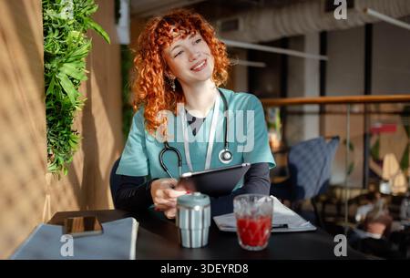 Junge Krankenschwester mit Smartphone in ihrer Pausenzeit Stockfoto