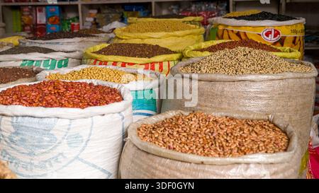 Verschiedene Bohnen (Phaseolus-Arten) Und Körner (Poaceae), die in Säcken auf einem Markt gelagert werden und eine reiche Auswahl an Grundnahrungsmitteln präsentieren. Stockfoto