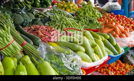 Verschiedene frische Gemüse in lebhaften Farben auf einem Marktstand, die eine lebhafte und reichhaltige Ausstellung von Produkten schaffen. Stockfoto