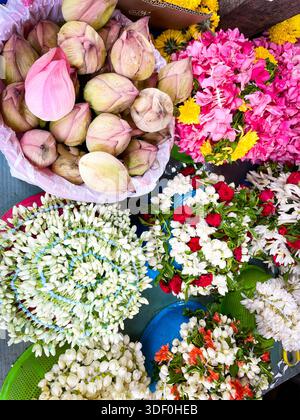 Farbenfrohe Auswahl an Lotusknospen und Blumengirlanden an einem Straßenmarkt mit Blick über singapur, asien Stockfoto
