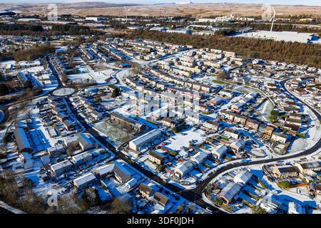Blick aus der Höhe auf eine walisische Stadt mit Schnee auf Dächern und einem Kreisverkehr Stockfoto