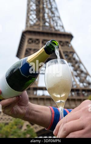 Ausgießen und Trinken von französischem Sekt aus Tulpenglas mit Blick auf die Straßen, Gebäude und Türme von Paris, Hochzeitsveranstaltung in Paris Stockfoto