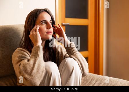 Junge Frau mit Kopfschmerzen, Migräne oder chronischen Schmerzen Stockfoto