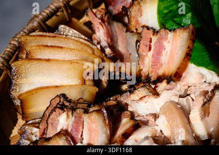 Geschnittenes, geräuchertes Schweinefleisch in Miao Bambustablett Stockfoto