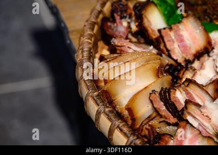 Geschnittenes, geräuchertes Schweinefleisch in Miao Bambustablett Stockfoto