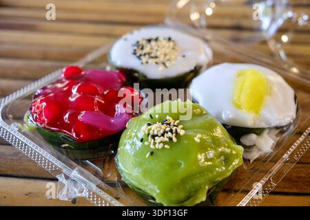 Khanom Tako im Khlong Lat Mayom, einem schwimmenden Markt in Bangkok: Ein thailändisches Dessert aus Glutinreismehl und Kokoscreme, Pandan und Hibiskusrose Stockfoto