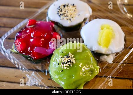 Khanom Tako im Khlong Lat Mayom, einem schwimmenden Markt in Bangkok: Ein thailändisches Dessert aus Glutinreismehl und Kokoscreme, Pandan und Hibiskusrose Stockfoto