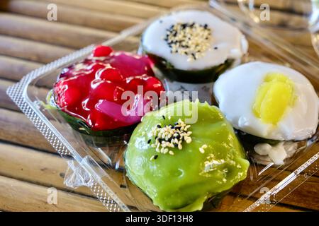 Khanom Tako im Khlong Lat Mayom, einem schwimmenden Markt in Bangkok: Ein thailändisches Dessert aus Glutinreismehl und Kokoscreme, Pandan und Hibiskusrose Stockfoto