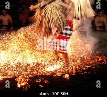 Künstler spazieren auf heißen Kohlen während der Kecak- und Feuertanz-Vorstellung im Pura Dalem Tempel in Ubud, Bali, Indonesien Stockfoto