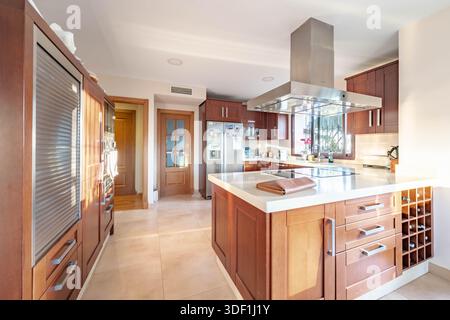 ein Bild einer modernen Küche mit Holzschränken in luxuriöser mediterraner Immobilien Stockfoto