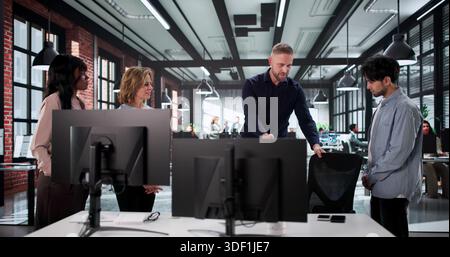 Professioneller Ergonomie-Trainer, Der Die Beurteilung Des Arbeitsplatzes Und Die Einstellung Des Schreibtisches Durchführt Stockfoto