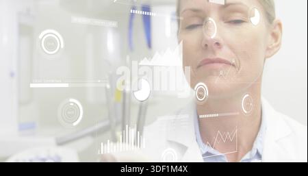 Untersuchung einer leitenden Ärztin in weißem Laborkittel, die mit HUD-Überlagerungen im klinischen Labor interagiert Stockfoto