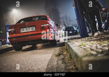 Rom, italien 9. januar 2025: Modifizierte bmw e36 Limousine parkt nachts unter Straßenlaternen und zeigt urbane Autokultur, Tuning-Details und leidenschaftliche hno Stockfoto