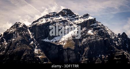 Schneebedeckter Berggipfel unter bewölktem Himmel Stockfoto