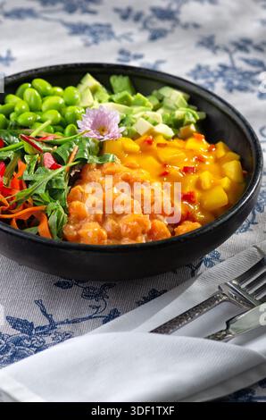 Köstliche Lachs- und Avocado-Poke-Schüssel garniert mit Sesamsamen und Algen, stilisierte Lebensmittelfotografie, lebendige Farbkomposition. Stockfoto