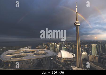 Blick auf einen pulsierenden doppelten Regenbogenbogen über dem kultigen CN Tower und Rogers Centre inmitten der belebten Stadtlandschaft, Toronto, Ontario, Kanada. Stockfoto