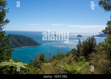 Ein atemberaubender Blick auf die Küste mit türkisfarbenem Wasser, üppigen grünen Hügeln und fernen Inseln unter einem klaren blauen Himmel. Ideal für die Natur und Reisen Stockfoto