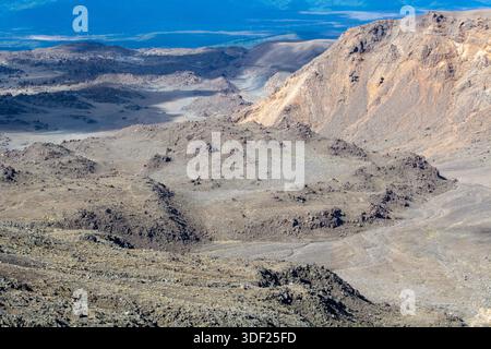 Aus der Vogelperspektive auf eine zerklüftete, felsige Landschaft mit vulkanischen Formationen und kargem Gelände. Die Szene fängt die natürliche Schönheit eines bergigen regi ein Stockfoto
