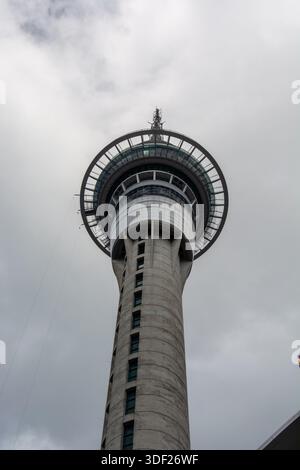 Ein flacher Blick auf einen hohen Betonturm mit einer kreisrunden Aussichtsplattform, umgeben von bewölktem Himmel. Stockfoto