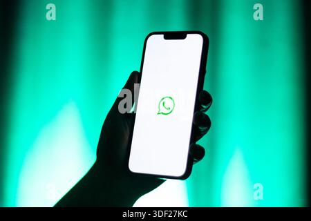 Kaliningrad, Russland - 12.11.2025. Frau hält das Smartphone und zeigt das WhatsApp-Logo auf dem Bildschirm. Online-App für Nachrichten und Anrufe Stockfoto