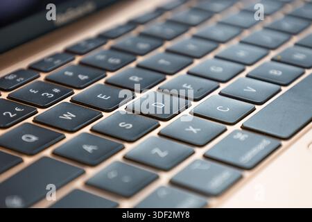 Detaillierte Nahaufnahme einer modernen Laptop-Tastatur mit schwarzen Tasten auf einer Metallic-Roségold-Oberfläche. Stockfoto