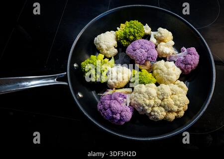 Verschiedene Wintergemüse in einer Pfanne: Weiße und violette Blumenkohlbraten (Brassica oleracea var. botrytis) und grüne Spirale Romanesco (Brassica oleracea var. botrytis) Stockfoto