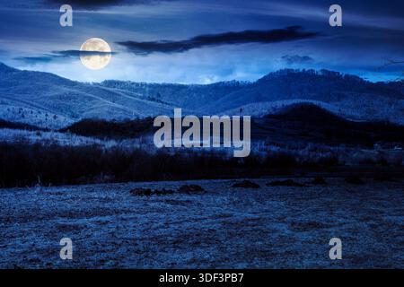 Wunderschöner Blick auf die Landschaft mit Feld im märz bei Vollmondlicht. Hintergrund für fiktive Kunst oder geheimnisvolle Konzepte Stockfoto