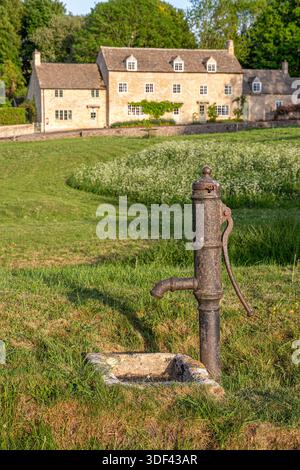 Abendlicht an der alten gusseisernen Wasserpumpe im Dorf Cotswold Little Barrington, Gloucestershire, England, Großbritannien Stockfoto