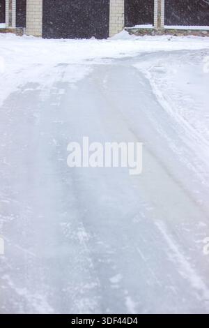 Vereiste Einfahrt in der Nähe des Hauses, gefährliche rutschige Oberfläche im Winter Stockfoto