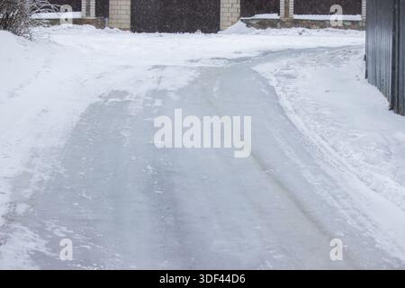 Vereiste Einfahrt in der Nähe des Hauses, gefährliche rutschige Oberfläche im Winter Stockfoto