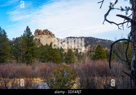 Granithügel, die sich über feuchte Wiesen und Kiefernwälder erheben, im Vedauwoo Recreation Area in Wyoming unter einem weiten Himmel, der die wilde Wildnis zeigt. Stockfoto