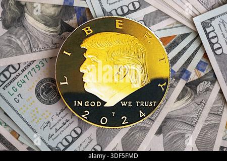 KIEW, UKRAINE - 13. DEZEMBER 2025 Trump Goldmünze auf großen Mengen von US-Dollar-Banknoten Stockfoto