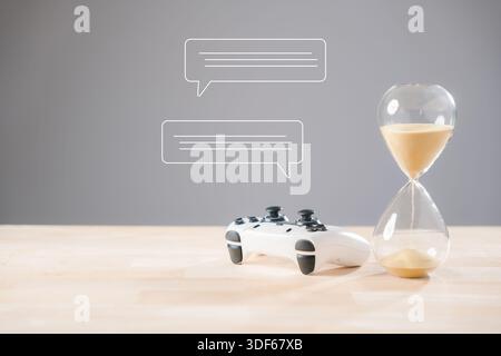 Gaming-Controller, Sanduhr und Chat-Blasen symbolisieren begrenzte Spielzeit und betonen das Zeitmanagement-Konzept, stundenlangen Sandlauf für wichtige V Stockfoto