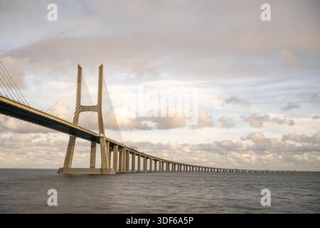 Lissabon Portugal 18. Dezember 2025. Die Vasco da Gama-Brücke erstreckt sich über den Tejo unter überlagerten Winterwolken. Stockfoto
