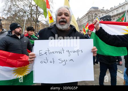 London, Großbritannien. Januar 2026. Ein Demonstrant hält während der Demonstration ein Plakat mit der Aufschrift „Extremisten aus Syrien raus“. Syrische kurdische Demonstranten versammelten sich vor der Downing Street in London, um die Entfernung extremistischer Gruppen aus Syrien zu fordern und die britische Regierung zu drängen, Sanktionen gegen die syrische Regierung zu verhängen. (Foto: Andrea Domeniconi/SOPA Images/SIPA USA) Credit: SIPA USA/Alamy Live News Stockfoto