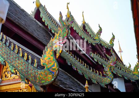 Komplizierte Naga-Schlangendach-Ornamente mit Glasmosaik am Wat Phra That Doi Kham Tempel auf der Bergseite von Chiang Mai, Nordthailand Stockfoto