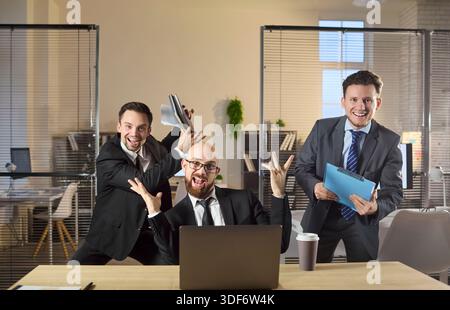 Geschäftsleute feiern Erfolg am Laptop im Büro, lustige Teamsiegstimmung Stockfoto